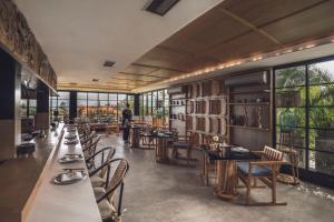a dining room with tables and chairs and windows at Amarea Resort & Spa Ubud by Ini Vie Hospitality in Ubud +44 photos