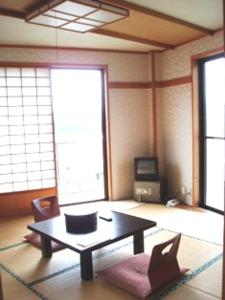 ein Wohnzimmer mit einem Couchtisch und einem TV in der Unterkunft Shinazawa in Nozawa Onsen