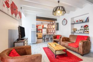 a living room with two couches and a table at Le Clemenceau in Les Épesses