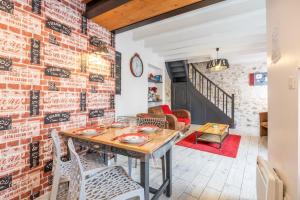 a dining room with a brick wall and a table and chairs at Le Clemenceau in Les Épesses