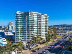 a tall building with a parking lot in front of it at Beach side Cotton Tree Family Friendly Resort in Maroochydore