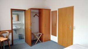 a bedroom with a wooden closet and a sink at PensionSchilling in Grasbrunn