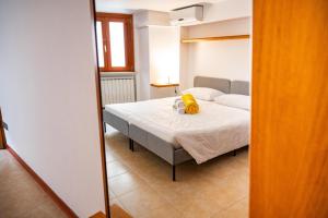 a bedroom with a bed with a yellow stuffed animal on it at La finestra sulla piazza in Pisticci
