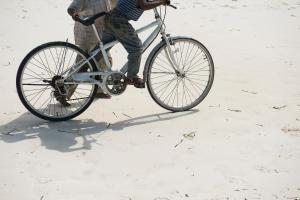 Ein Mann, der am Strand Fahrrad fährt in der Unterkunft Retro in Zanzibar City