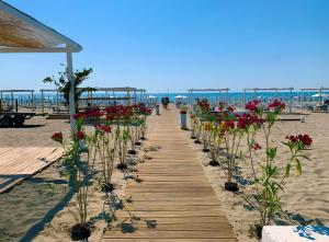 a wooden pathway with flowers on the beach at La finestra sulla piazza in Pisticci