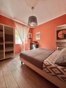 a bedroom with orange walls and a bed and a window at Villa Sea Rose in Lipari