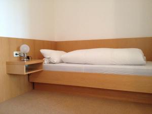 a bedroom with a bed with a wooden headboard at PensionSchilling in Grasbrunn