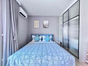 a bedroom with a blue bed with blue pillows at Title Legendary 7 floor Mountain View in Bang Tao Beach