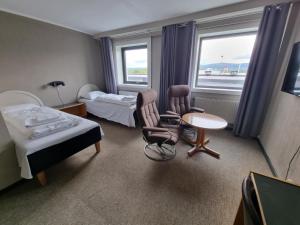 a hotel room with two beds and a table and chairs at Verdde Hotel Lakselv in Lakselv +34 photos