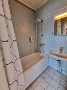 a bathroom with a bath tub and a sink at Verdde Hotel Lakselv in Lakselv