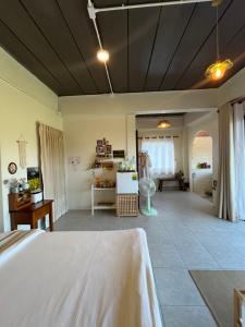 a bedroom with a large bed and a living room at หมี่ก่าโฮมสเตย์ in Ban Pha Mi