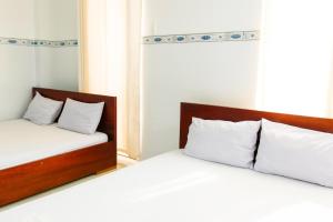 two beds sitting next to each other in a bedroom at Nam Dương 1 Hotel in Phan Rang–Tháp Chàm