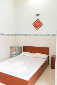 a bedroom with a bed with white sheets and a sign on the wall at Nam Dương 1 Hotel in Phan Rang–Tháp Chàm +19 photos