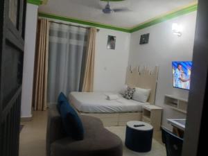 Mash Studio Apartment in Bamburi في مومباسا: غرفة نوم صغيرة بها سرير وكرسي