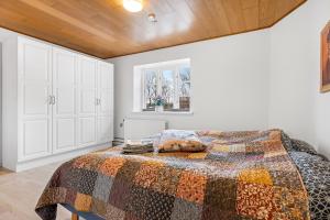 a bedroom with a bed with a quilt on it at Naturskønt nær Ribe Vikingecenter, se og oplev den gamle by Ribe in Ribe