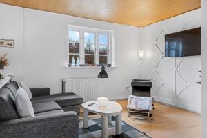 a living room with a couch and a table at Naturskønt nær Ribe Vikingecenter, se og oplev den gamle by Ribe in Ribe