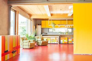 a kitchen with yellow cabinets and couches in a room at SELBSTgemacht in Arnsgrün