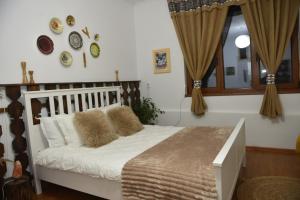 a bedroom with a white bed with pillows on it at Agroturism Sesuri 151 in Şesuri