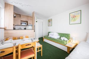 une petite chambre avec un lit et une cuisine dans l'établissement Appartement Necou 105, aux Menuires
