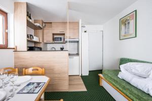 un petit appartement avec un lit, une table et une cuisine dans l'établissement Appartement Necou 105, aux Menuires 13 autres photos