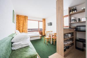 une chambre d'hôtel avec un lit et une table dans l'établissement Appartement Necou 105, aux Menuires