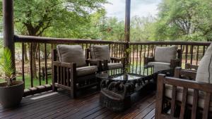 un portico con sedie, tavolo e recinzione di Vida Nova Kruger a Marloth Park Altre 30 foto