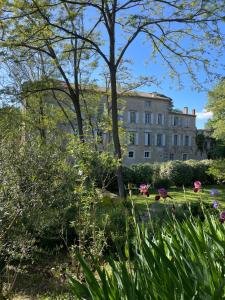 Blick auf ein Gebäude aus den Gärten in der Unterkunft La Manufacture Royale 1739 in Montolieu