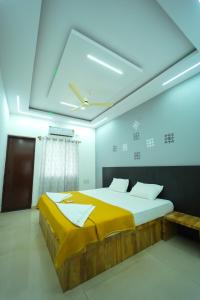 a bedroom with a bed with a yellow blanket on it at Nandan Elite 3bhk in Mysore