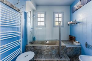 a blue bathroom with a tub and a toilet at Chambre D'hote Chez Amaya in Gujan-Mestras +15 photos