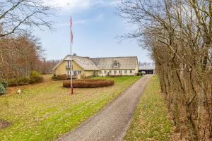a house with a flag on a dirt road at Naturskønt nær Ribe Vikingecenter, se og oplev den gamle by Ribe in Ribe