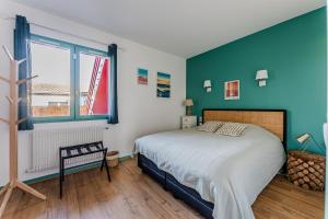 a bedroom with a bed and a green wall at Chambre D'hote Chez Amaya in Gujan-Mestras