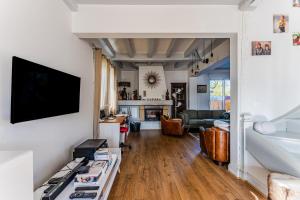 a living room with a tv on a wall at Chambre D'hote Chez Amaya in Gujan-Mestras