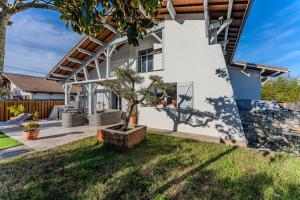 a tree in a planter in front of a house at Chambre D'hote Chez Amaya in Gujan-Mestras