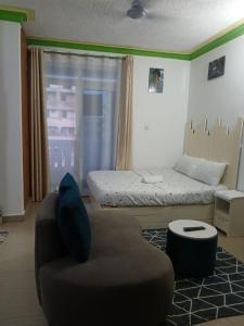 Mash Studio Apartment in Bamburi في مومباسا: غرفة معيشة بها أريكة وسرير