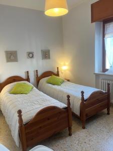 two twin beds in a bedroom with a window at B&b Cristina - Appartamento Monte Coccia in Campo di Giove