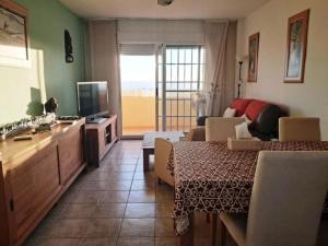 een woonkamer met een bank, een tafel en een televisie bij Superb Location! in Plettenbergbaai