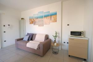 Bilocale in Residence Piazza Brescia في ليدو دي يسولو: غرفة معيشة مع أريكة وتلفزيون