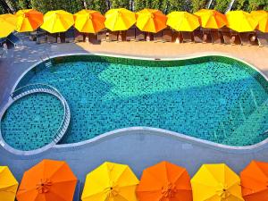 an overhead view of a swimming pool with colorful umbrellas at Ibis Hua Hin in Hua Hin