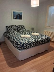 a bedroom with a bed with a black and white comforter at Le Florin d'Or - Bords de Creuse in Saint-Gaultier