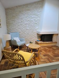 ein Wohnzimmer mit Stühlen und einem Kamin in der Unterkunft Maison proche commerce, 20 min du Futuroscope in Vouillé