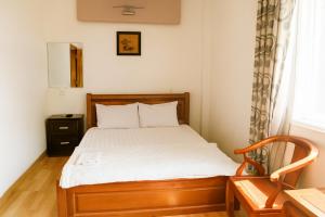 a bedroom with a bed and a chair and a window at Nam Dương 2 Hotel in Phan Rang–Tháp Chàm