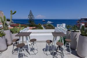 a patio with stools and a view of the ocean at Villa Sea Rose in Lipari