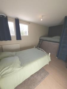 ein Schlafzimmer mit einem Bett und zwei Etagenbetten in der Unterkunft Maison proche commerce, 20 min du Futuroscope in Vouillé