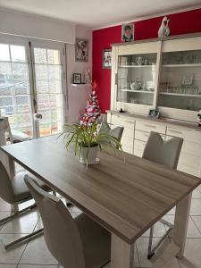 a dining room with a table and a christmas tree at Chambre d'hote Reine in Cancale