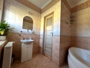 a bathroom with a tub and a sink and a toilet at Apartament Centrum 3 pokojowy z widokiem na morze in Sarbinowo