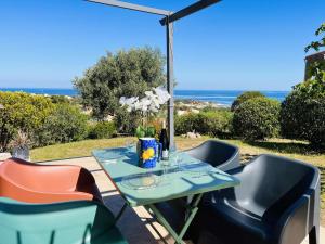 a table and chairs with a view of the ocean at Appartement Cocody 215 LUMIO in Lumio