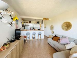 a living room with a couch and a kitchen at Appartement Cocody 215 LUMIO in Lumio