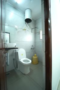 a bathroom with a white toilet and a sink at Nandan Elite 3bhk in Mysore