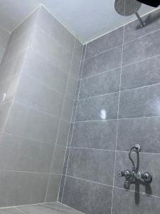 y baño con ducha y suelo de baldosa. en موتيلى دانزه اربيل 3, en Erbil