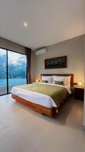 a bedroom with a large bed and a large window at 3BR Nava villa Ubud in Ubud +29 photos